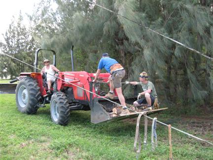 Dan, Dave, and Easton move logs with the tractor
